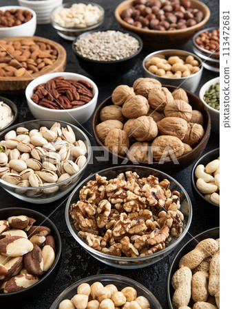 Raw walnuts and cashew with almonds and peanuts with organic nuts and seed in various assorted bowls 113472681