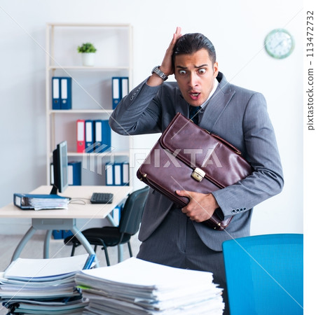 Businessman with heavy paperwork workload 113472732