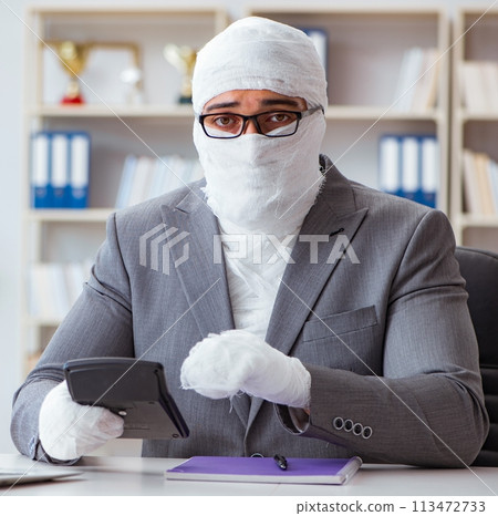 Bandaged businessman worker working in the office doing paperwor 113472733