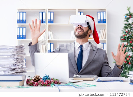 Young businessman celebrating christmas in the office 113472734
