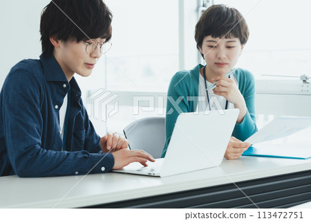 在計算機上工作的年輕男女 113472751