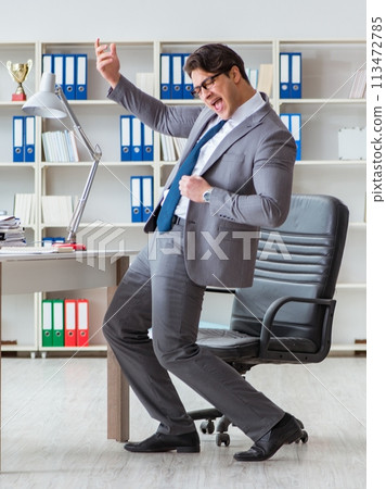 Businessman having fun taking a break in the office at work Businessman having fun taking a break in the office at work 113472785