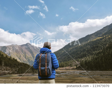 rear view of asian man looking at view while traveling rear view of asian man looking at view while traveling 113473070