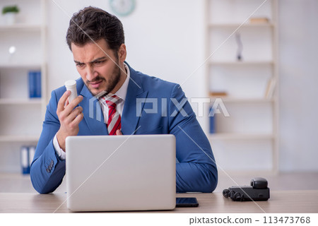Young male employee feeling bad at workplace 113473768