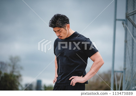 一名40多歲的男子在戶外訓練時休息 113473889