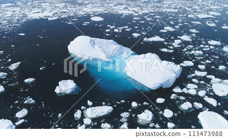Aerial Flight Over Iceberg Among Antarctica Ocean. Climate Change in Winter Ocean Scape. Drone Of Huge Ice Glacier, Snow Pieces Floating In Clear Ocean Water. Antarctic Polar Scene. Aerial Flight Over Iceberg Among Antarctica Ocean. Climate Change in Winter Ocean Scape. Drone Of Huge Ice Glacier, Snow Pieces Floating In Clear Ocean Water. Antarctic Polar Scene. 113473988