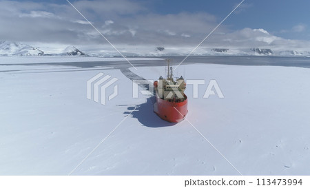 Icebreaker vessel navigating Antarctic waters - breaks through pack ice on its way. Aerial view. Featuring red color Laurence M. Gould Research Boat slicing through the Southern Ocean's ice expanse Icebreaker vessel navigating Antarctic waters - breaks through pack ice on its way. Aerial view. Featuring red color Laurence M. Gould Research Boat slicing through the Southern Ocean's ice expanse 113473994