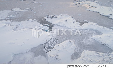 Aerial flight over polar ocean, Vernadsky station. Antarctica drone. Epic overview of frozen ocean. Glaciers, icebergs, pieces of ice in cold water. Settlement in wild harsh nature. 113474168