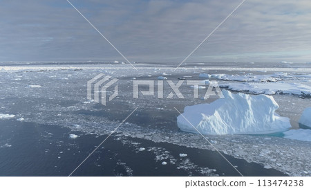 Open Water Glacier Iceberg Above Speed Flight View. Ice Melt in Winter Ocean Water Surface Fly Drone Overview. Antarctica Climate Change Concept Open Water Glacier Iceberg Above Speed Flight View. Ice Melt in Winter Ocean Water Surface Fly Drone Overview. Antarctica Climate Change Concept 113474238