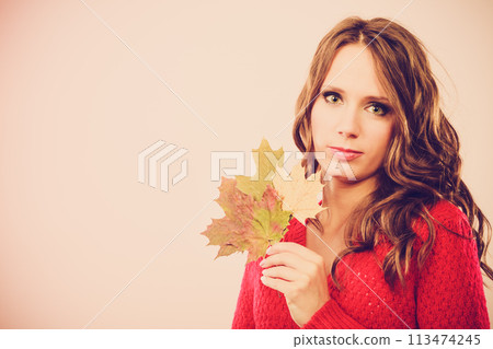 Pretty autumnal girl with maple leaves in hand Pretty autumnal girl with maple leaves in hand 113474245