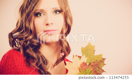 Pretty autumnal girl with maple leaves in hand Pretty autumnal girl with maple leaves in hand 113474255