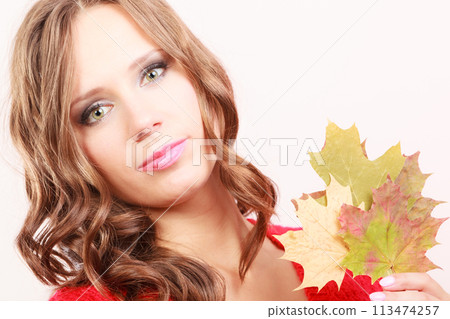 Fashion autumnal girl with maple leaves in hand Fashion autumnal girl with maple leaves in hand 113474257