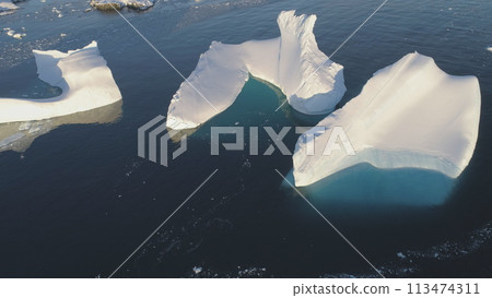 Iceberg Melt in Clear Ocean Drone Top Down View. Huge Snow Ice Float in Sea, Global Climate Change Concept Pan Left Flight. South Pole Glacier Landscape. 113474311