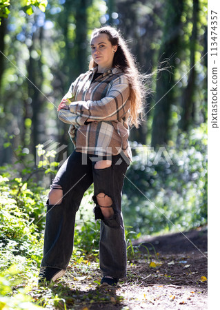 Woman Standing in Woods With Arms Crossed Woman Standing in Woods With Arms Crossed 113474357