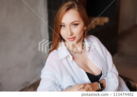 Portrait of sexy redhead young woman in white shirt.  113474402