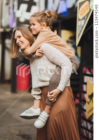 mum and teenage daughter having fun on a walk in the city. mum and teenage daughter having fun on a walk in the city. 113474548