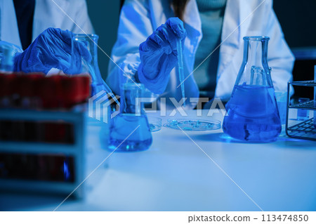 Science and medicine, scientist analyzing and dropping a sample into a glassware, experiments containing chemical liquid in laboratory on glassware, innovative and technology. Science and medicine, scientist analyzing and dropping a sample into a glassware, experiments containing chemical liquid in laboratory on glassware, innovative and technology. 113474850