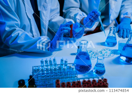 Science and medicine, scientist analyzing and dropping a sample into a glassware, experiments containing chemical liquid in laboratory on glassware, innovative and technology. 113474854