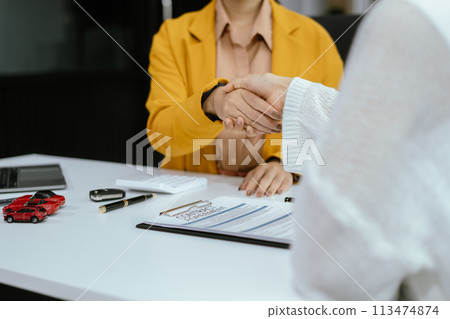 Close up shake hands, Car Dealership and sign contracts in car showrooms or car dealership offices, successful deal. Close up shake hands, Car Dealership and sign contracts in car showrooms or car dealership offices, successful deal. 113474874