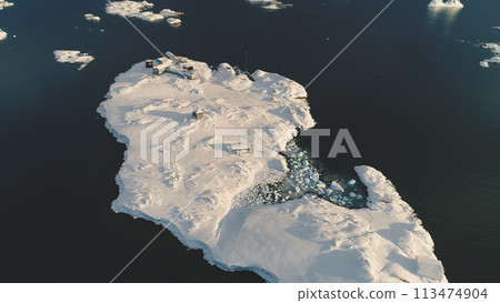 Top-down helicopter landing above Antarctic polar station - Vernadsky Base. Ocean water surface. Snow covered south pole settlement. Nature landscape aerial drone view. Flight Top-down helicopter landing above Antarctic polar station - Vernadsky Base. Ocean water surface. Snow covered south pole settlement. Nature landscape aerial drone view. Flight 113474904