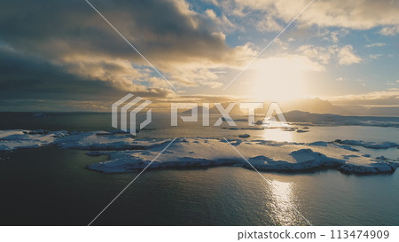 Sunset Above Antarctica Snow Island Aerial Front View. Antarctic Winter Ocean Water. Beautiful Sky Horizon Landscape Drone Takeoff Flight 113474909
