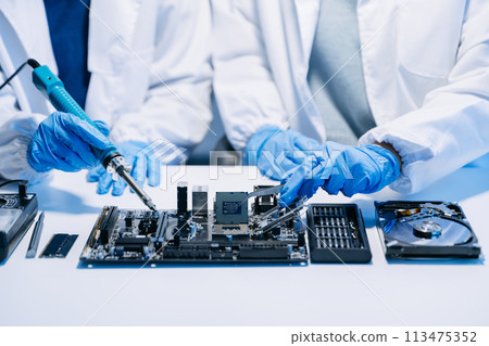 The technician is putting the CPU on the socket of the computer motherboard. electronic engineering electronic repair, electronics measuring. 113475352