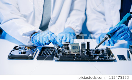 The technician is putting the CPU on the socket of the computer motherboard. electronic engineering electronic repair, electronics measuring. 113475353