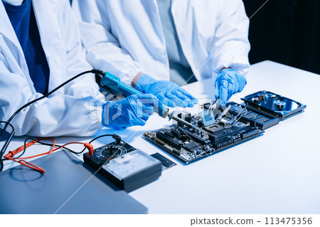 The technician is putting the CPU on the socket of the computer motherboard. electronic engineering electronic repair, electronics measuring. The technician is putting the CPU on the socket of the computer motherboard. electronic engineering electronic repair, electronics measuring. 113475356