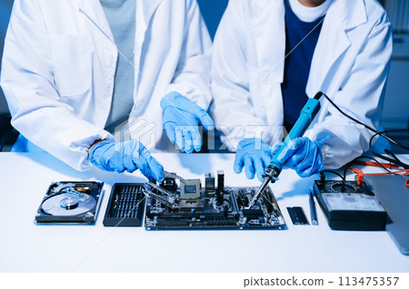 The technician is putting the CPU on the socket of the computer motherboard. electronic engineering electronic repair, electronics measuring. The technician is putting the CPU on the socket of the computer motherboard. electronic engineering electronic repair, electronics measuring. 113475357