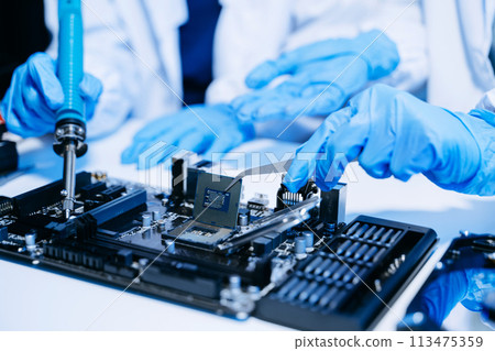 The technician is putting the CPU on the socket of the computer motherboard. electronic engineering electronic repair, electronics measuring. The technician is putting the CPU on the socket of the computer motherboard. electronic engineering electronic repair, electronics measuring. 113475359