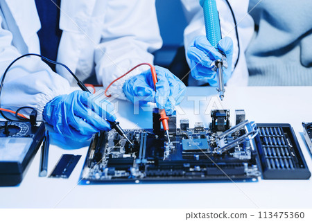 The technician is putting the CPU on the socket of the computer motherboard. electronic engineering electronic repair, electronics measuring. The technician is putting the CPU on the socket of the computer motherboard. electronic engineering electronic repair, electronics measuring. 113475360
