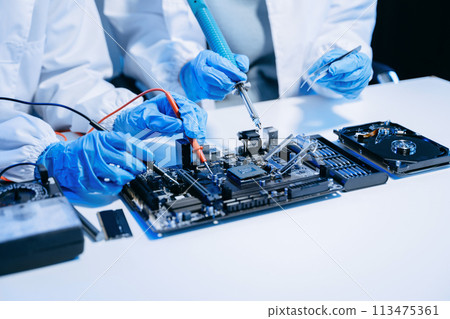 The technician is putting the CPU on the socket of the computer motherboard. electronic engineering electronic repair, electronics measuring. 113475361