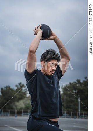 A man in his 40s doing strength training outdoors A man in his 40s doing strength training outdoors 113475489