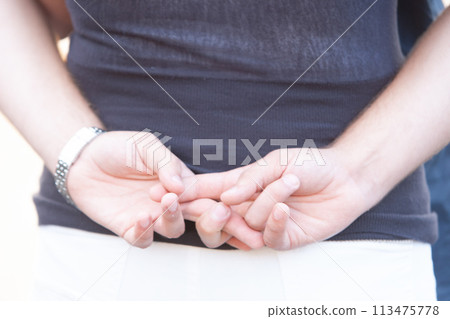 Close-Up of Man's Hands Clasped Together in a Casual Pose 113475778