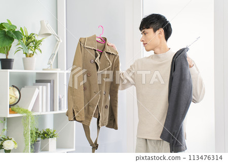 Man arranging his clothes 113476314
