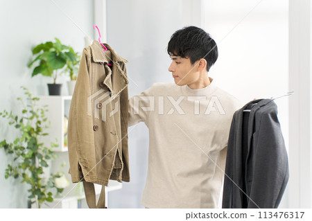 Man arranging his clothes Man arranging his clothes 113476317