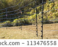 Electric fences stretched across farmland to keep out pests 113476558
