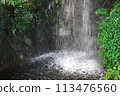 A small waterfall cascading down, splashing 113476560