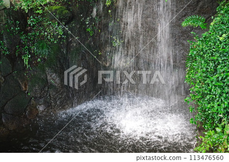 A small waterfall cascading down, splashing 113476560
