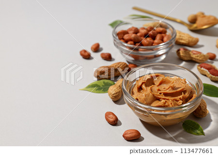 Peanut paste in a transparent plate, on a light background. 113477661