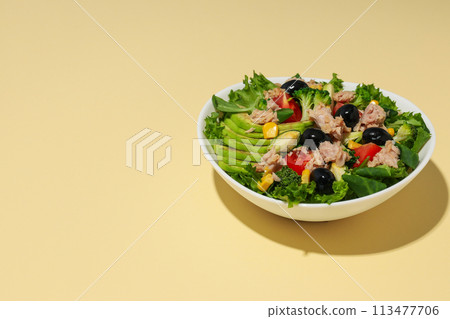 Salad with tuna on a yellow background. 113477706