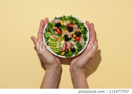 Salad with tuna on a yellow background. 113477707
