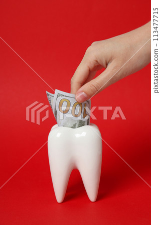 Cash in tooth and hand on red background 113477715