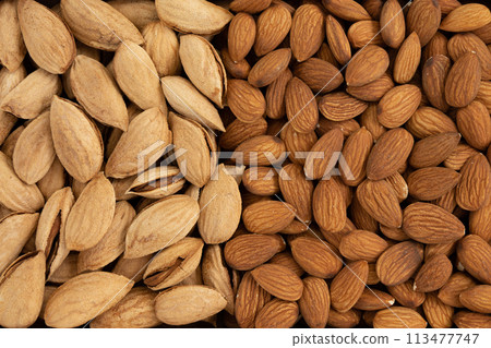background of peeled and unpeeled almond nuts, close up background of peeled and unpeeled almond nuts, close up 113477747