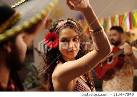 Dancing woman with red gerbera in hair 113477849