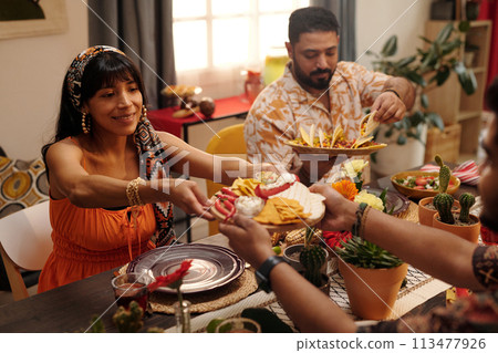 Happy girl taking snacks over table 113477926