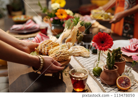 Putting tray with homemade corn on table Putting tray with homemade corn on table 113478050