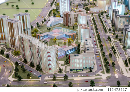 A miniature city on the table. Layout of a block with a residential building and a park. A miniature city on the table. Layout of a block with a residential building and a park. 113478517