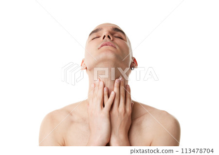 Young shirtless man with bald head, shaved face taking care after skin in bathroom isolated on white studio background 113478704