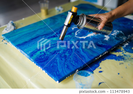 Artist Applying Heat to Epoxy Resin Art 113478943